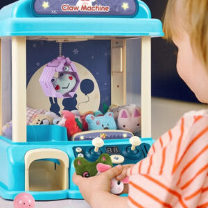 Child playing with a mini claw machine toy with plush prizes and capsule balls